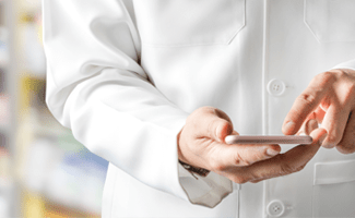 Ein Arzt im weißen Kittel benutzt sein Smartphone