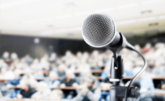 Ein voller Hörsaal mit einem aufgestellten Mikrofon im Vordergrund